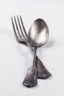 Closeup view of old silver spoon and fork on white surface — Stock Photo