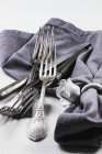 Closeup view of old silver cutlery with a grey napkin on a white tablecloth — Stock Photo
