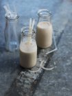 Milkshake with nuts in jars with straws — Stock Photo