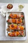 Roast butternut squash wedges with bacon on tray over towel — Stock Photo