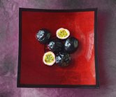 Frutas de la pasión en tazón de fruta roja - foto de stock
