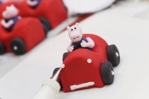 Closeup view of a fondant race car with a pig on a white surface — Stock Photo