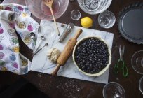 Вид зверху на чорницю з тістом, лимоном та посудом — стокове фото