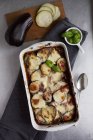 Aubergine bake with Bechamel sauce and basil in white baking dish over towel — Stock Photo