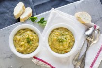 Potato soup in bowls with baguette — Stock Photo