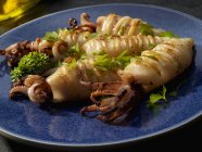 Primo piano vista di calamari grigliati interi con aglio e prezzemolo — Foto stock