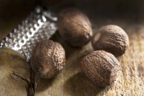 Nutmegs enteros y rallador - foto de stock