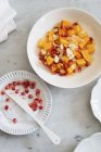Closeup view of Persimon salad with pomegranate seeds and flaked almonds — Stock Photo