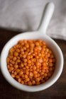 Vista close-up de uma tigela branca de lentilhas vermelhas — Fotografia de Stock