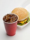 Cheeseburger in packing box with cola — Stock Photo