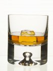 Glass of whisky with ice cube — Stock Photo