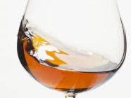 Cognac tourbillonnant dans un verre — Photo de stock