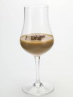 Closeup view of cream liqueur with ice cubes in glass — Stock Photo