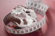 Tratamento de marshmallow revestido de chocolate esmagado em fundo vermelho — Fotografia de Stock