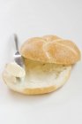 Rolo de pão com manteiga com faca — Fotografia de Stock