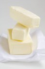 Vista de primer plano de bloques apilados de mantequilla sobre papel - foto de stock