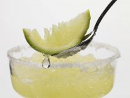 Frozen Margarita with lime wedge on spoon — Stock Photo