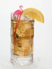 Rum drink with ice cubes and orange wedge — Stock Photo
