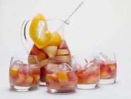 Red wine punch in glass jug and glasses — Stock Photo