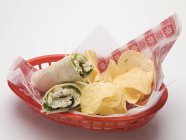 Closeup view of wraps with crisps in a red plastic basket — Stock Photo