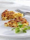 Patata y tocino rsti en plato blanco con tenedor - foto de stock