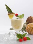 Крупный план коктейля Пина Колада с кубиками льда, ананасами, вишнями и мятными листьями — стоковое фото