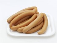 Closeup view of Frankfurters sausages heap on white plate — Stock Photo