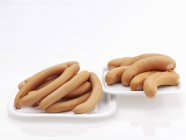 Closeup view of Frankfurters and Bockwursts sausages on white plates — Stock Photo