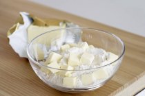 Vue rapprochée du beurre en dés et de la farine dans un bol en verre — Photo de stock