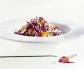 Тарелка салата из красной и белой капусты на белой поверхности — стоковое фото