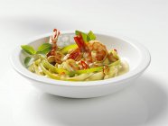 Closeup view of chilli prawns with herbs and sauce in white bowl — Stock Photo