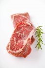Carne fresca cruda con romero - foto de stock