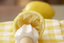 Squeezed lemon half with squeezer — Stock Photo