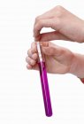 Cropped view of hands holding litmus paper in test-tube — Stock Photo
