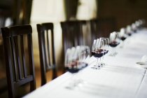 Mesa com copos de vinho tinto — Fotografia de Stock