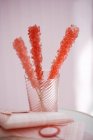 Closeup view of three pieces of pink rock candy in glass — Stock Photo