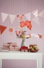 Tisch mit Süßigkeiten, Geschenken und Papierfahnen gedeckt — Stockfoto