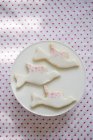 Gros plan vue de dessus de trois biscuits en forme de colombe avec glaçage blanc et rose — Photo de stock