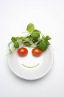 Овощное лицо в тарелке с супом на белой поверхности — стоковое фото