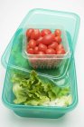 Lechuga en caja de almacenamiento de alimentos con tomates - foto de stock