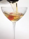 Pouring Manhattan cocktail into glass — Stock Photo
