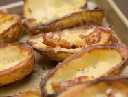 Baked potato skins with bacon in baking dish — Stock Photo