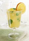 Closeup view of iced drink with mint and orange in glass — Stock Photo