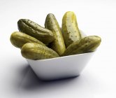 Pickles dans un bol blanc carré sur fond blanc — Photo de stock