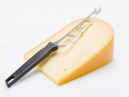 Piece of Gouda with knife — Stock Photo