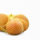 Fresh grapefruits in net — Stock Photo