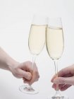 Hands clinking glasses of sparkling wine — Stock Photo