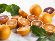Вдвое меньше кровавых апельсинов с листьями — стоковое фото