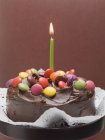 Cake with chocolate and candle — Stock Photo