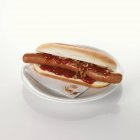 Cachorro quente com ketchup na placa — Fotografia de Stock